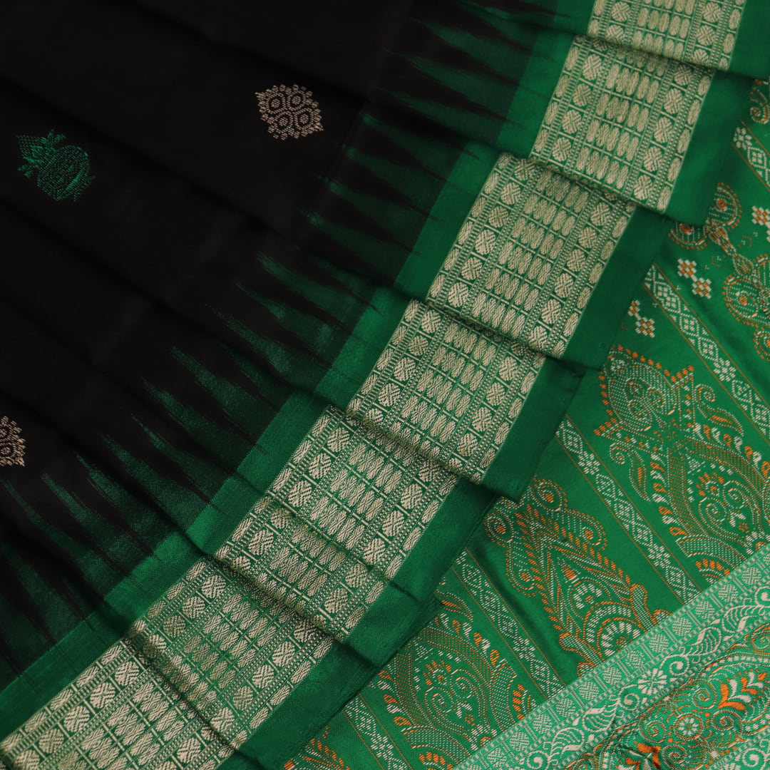 Close-up view of black silk Bomkai saree, showcasing intricate butta patterns and green accents