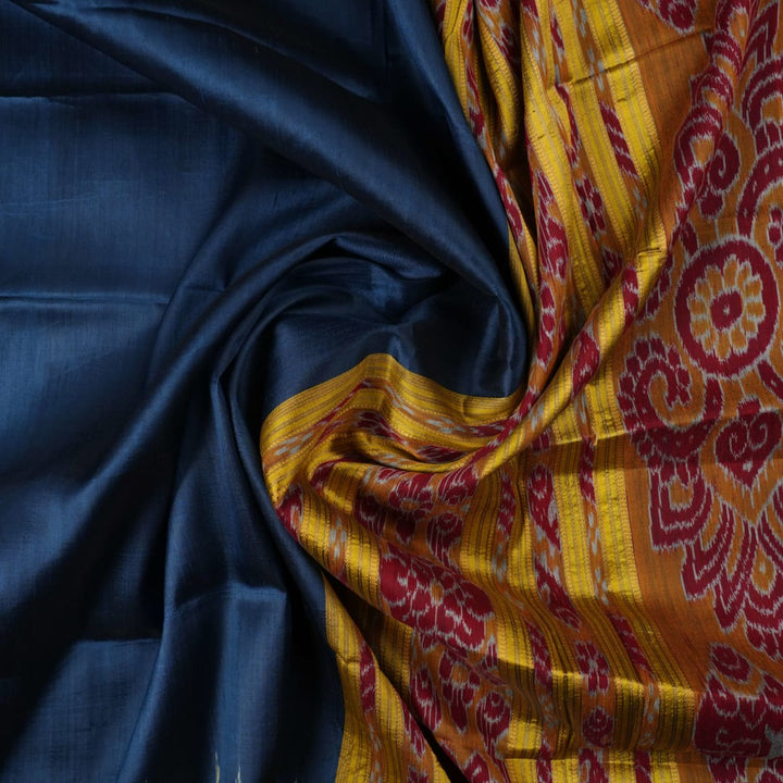 Model styling a blue and yellow Khandua silk saree with traditional butta work and border.
