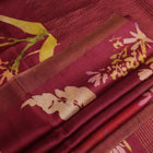 Close-up of maroon Tussar silk saree fabric, emphasizing its distinct texture and printed pattern.