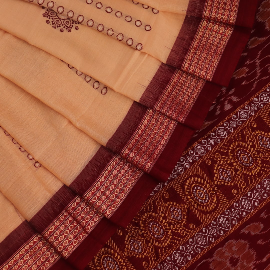 Full view of a cream cotton Bomkai saree with a maroon butta pattern.