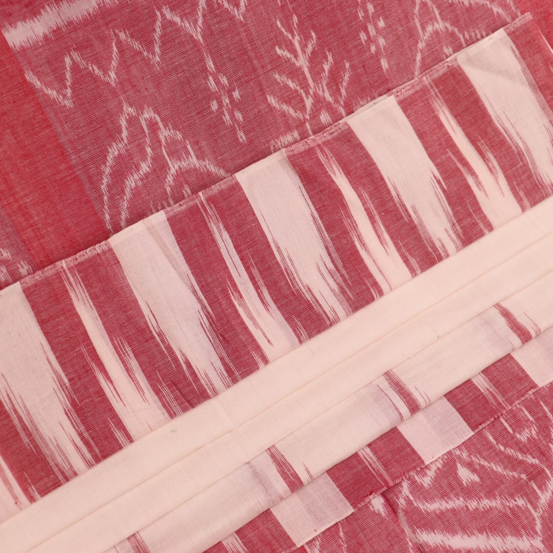 Plain white and maroon Sambalpuri cotton saree styled to show its drape and color combination.