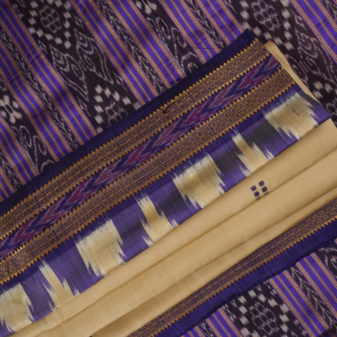 Model draped in a cream and blue Khandua silk saree with butta patterns, showcasing traditional styling.