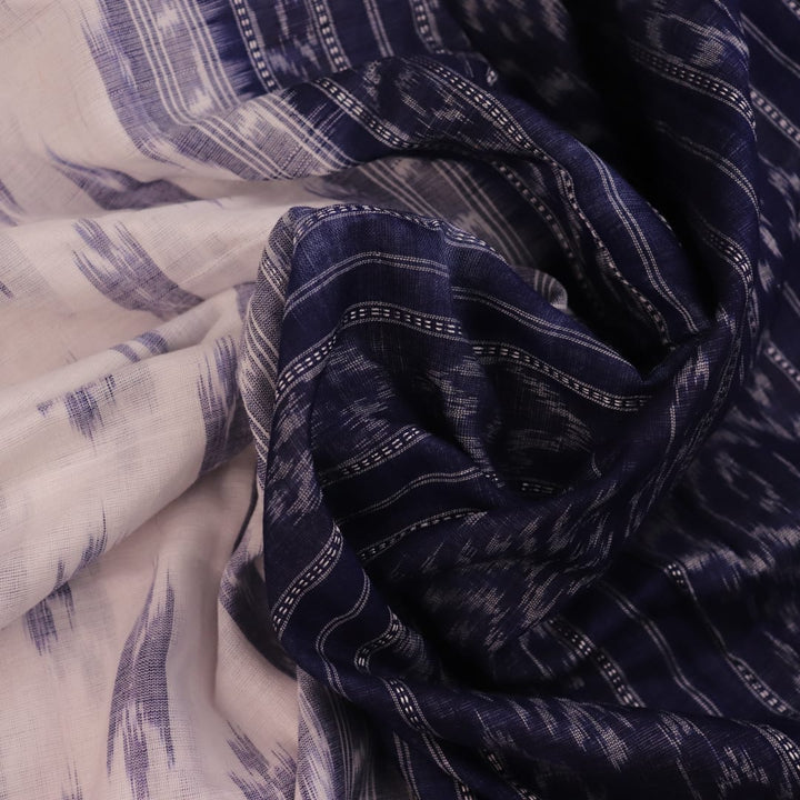 Model wearing a white Sambalpuri cotton saree with blue motifs, showcasing the drape and overall look.