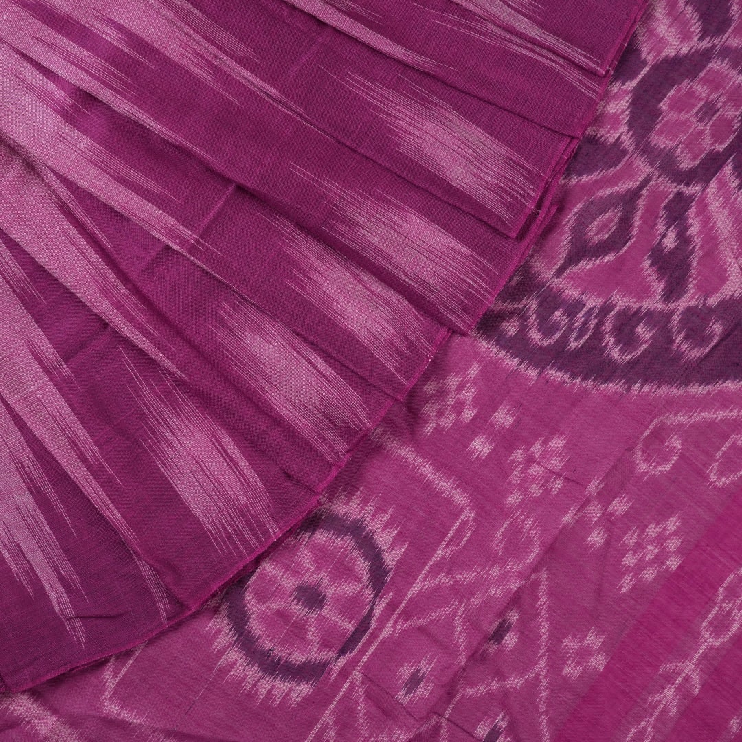 Model draped in a plain pink Sambalpuri cotton saree, styled to show the graceful fall and elegant border.