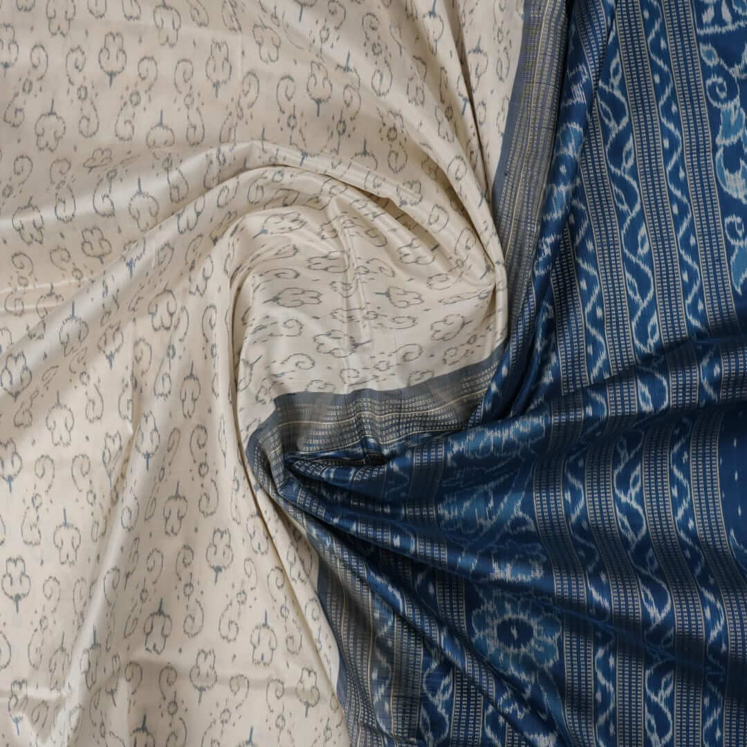 Close-up of premium fabric texture and handloom weave on a white and blue Sambalpuri silk saree