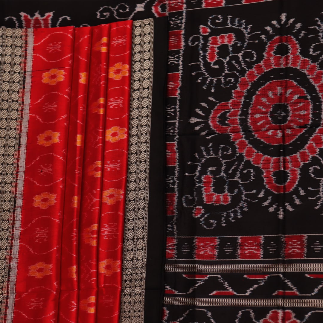 Close-up of red and black silk Sambalpuri saree fabric with intricate motifs