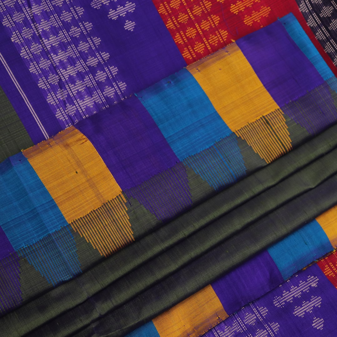 Close-up of the green silk fabric with a butta pattern in the Berhampuri saree