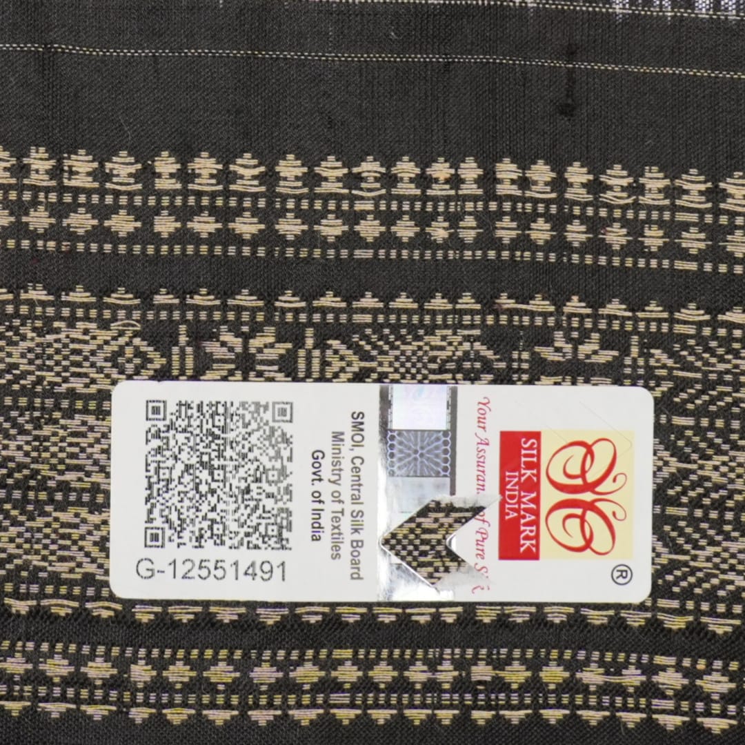 Extreme close-up of black Sambalpuri silk saree fabric, highlighting its luxurious texture and weave.