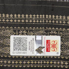 Extreme close-up of black Sambalpuri silk saree fabric, highlighting its luxurious texture and weave.