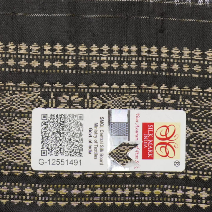 Extreme close-up of black Sambalpuri silk saree fabric, highlighting its luxurious texture and weave.