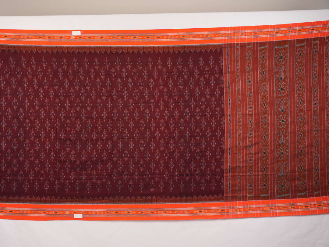 Model draped in a maroon and orange Sambalpuri cotton saree showcasing traditional handloom motifs.