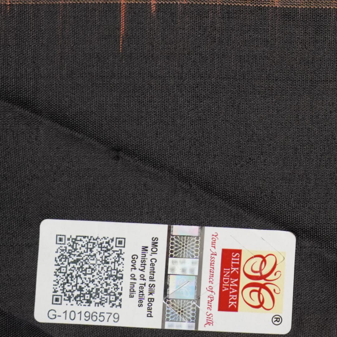 Extreme close-up of brown Bomkai silk saree fabric, revealing rich weave texture and luxurious feel.