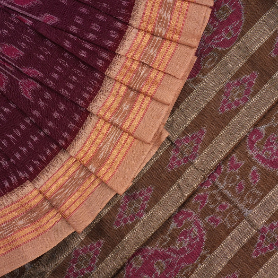 Model wearing an elegantly draped maroon and brown Sambalpuri cotton saree with traditional ikat motifs.