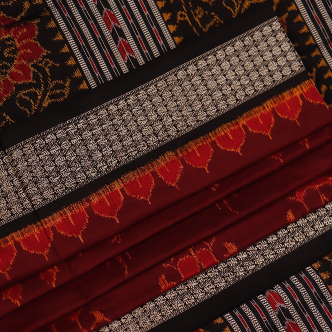 Close-up of intricate motifs on a maroon Sambalpuri silk saree