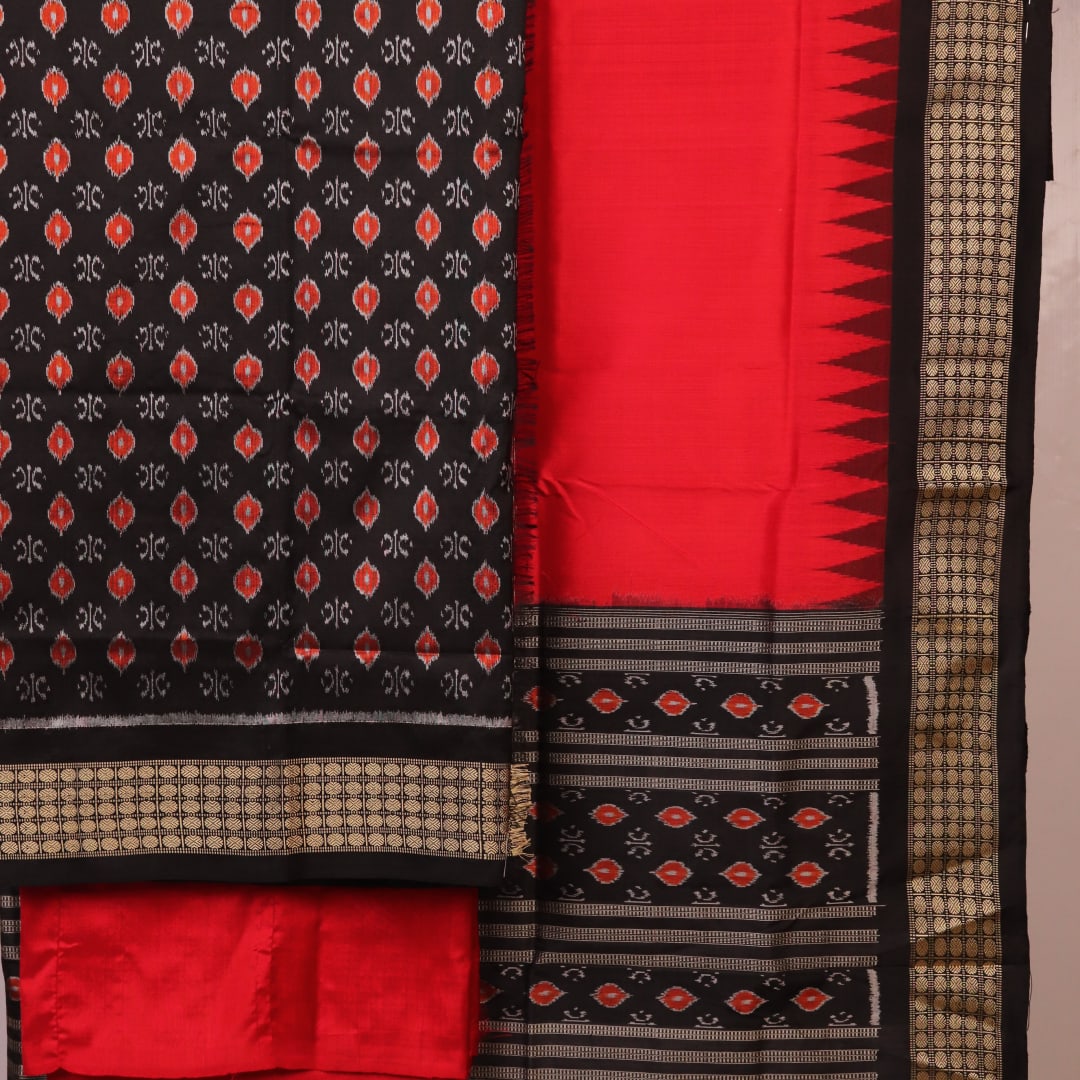 Detail of black Sambalpuri silk blouse piece from dress material, featuring red motifs.