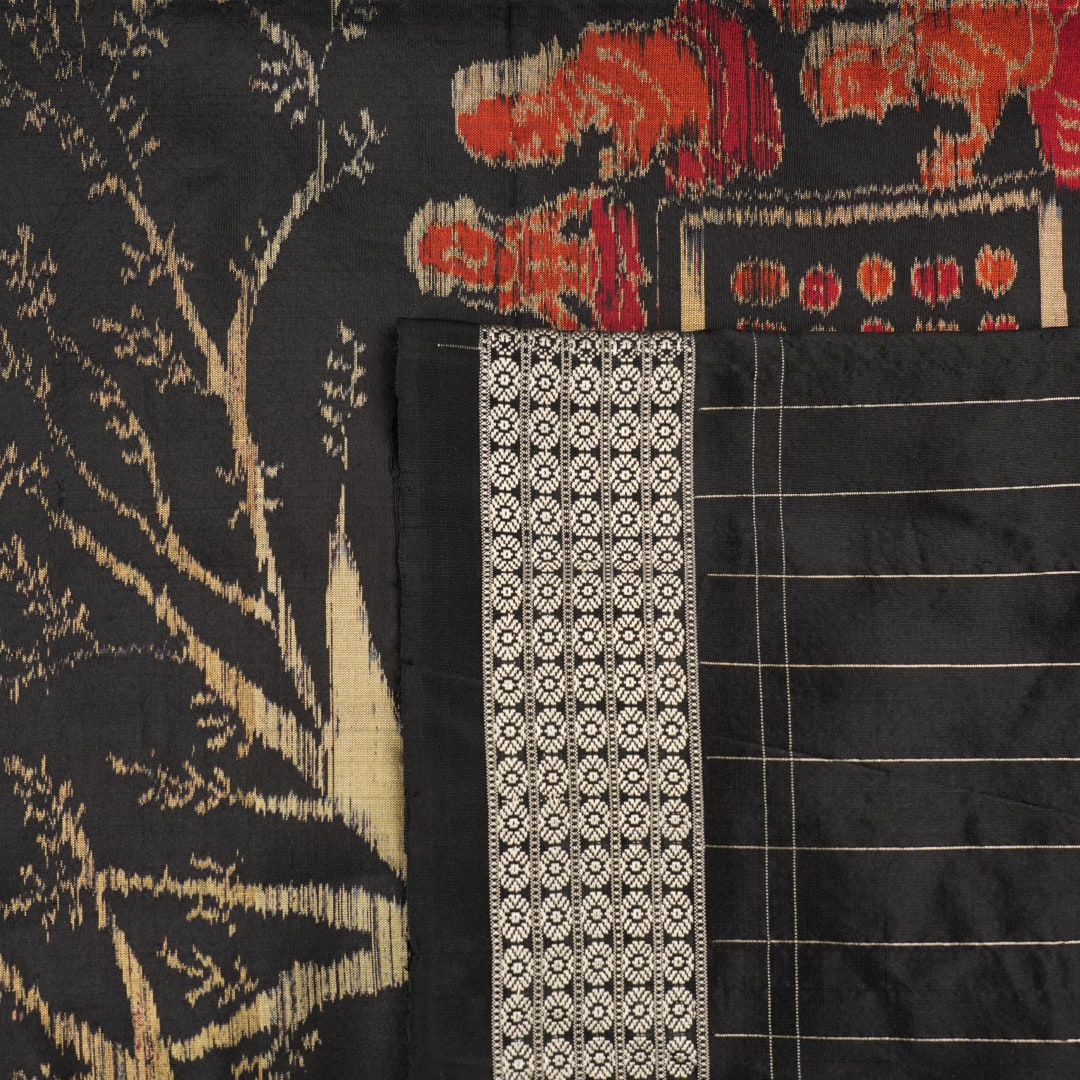 Close-up of the luxurious black Sambalpuri silk fabric, highlighting its rich texture and weave.