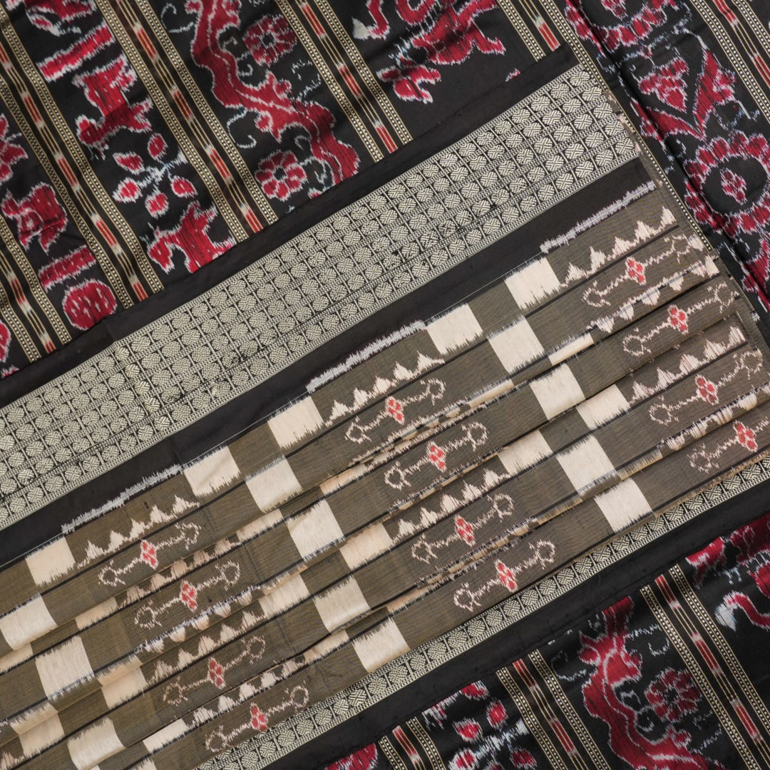 Close-up of the luxurious silk fabric texture and handloom weave of the grey and black Sambalpuri saree.