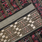 Close-up of the luxurious silk fabric texture and handloom weave of the grey and black Sambalpuri saree.