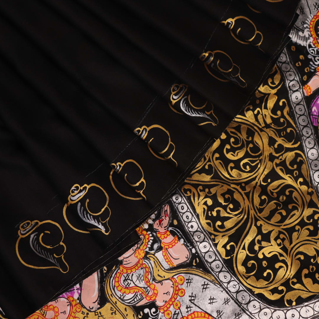Close-up of black silk Patachitra saree fabric, showcasing hand-painted texture and detail.