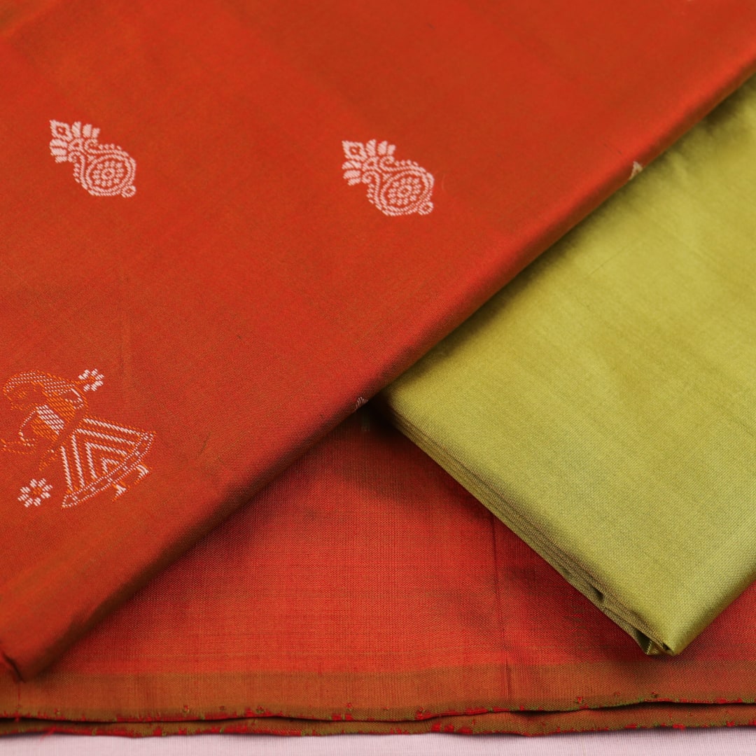 Detail of rust and green Bomkai silk blouse piece with butta pattern.