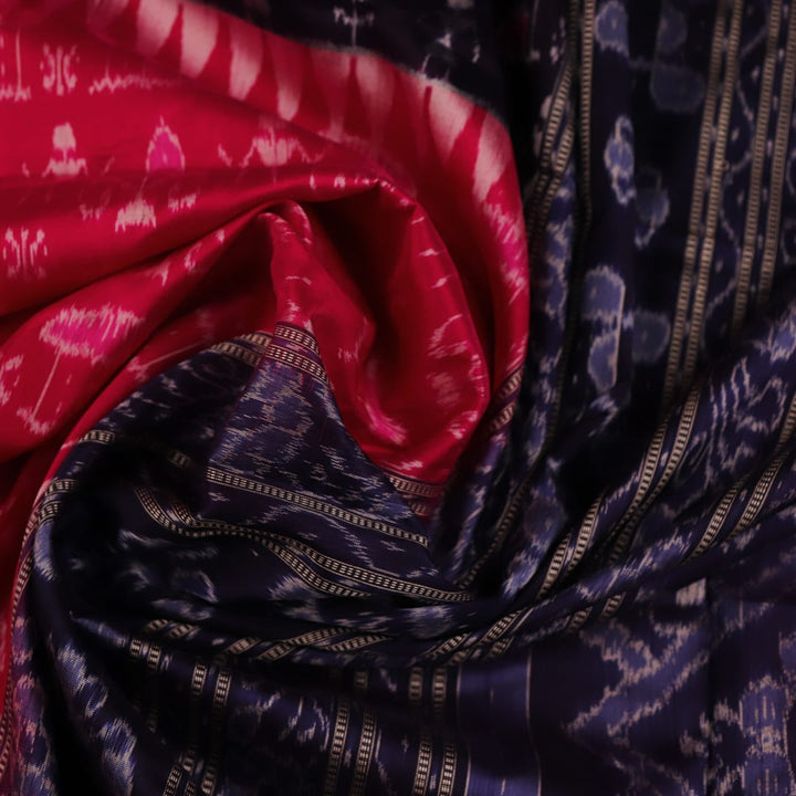 Close-up showing the intricate silk fabric texture of a magenta Sambalpuri saree with multicolor motifs.