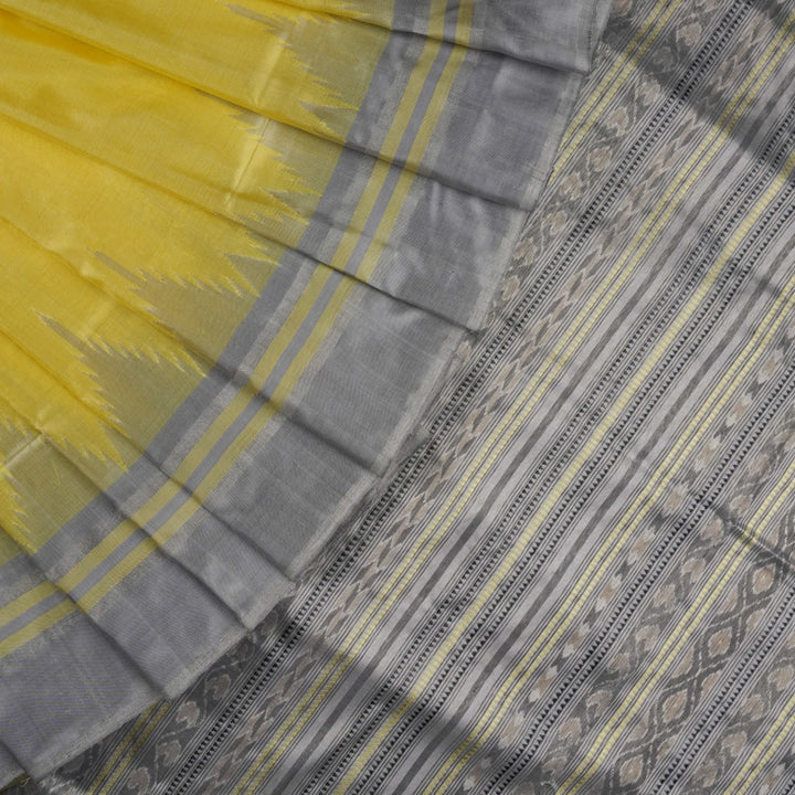 Close-up of the luxurious yellow Sambalpuri silk fabric, showing its fine weave and texture.