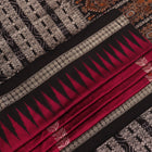 Close-up of magenta and black Bomkai silk saree texture, showing butta pattern weave.