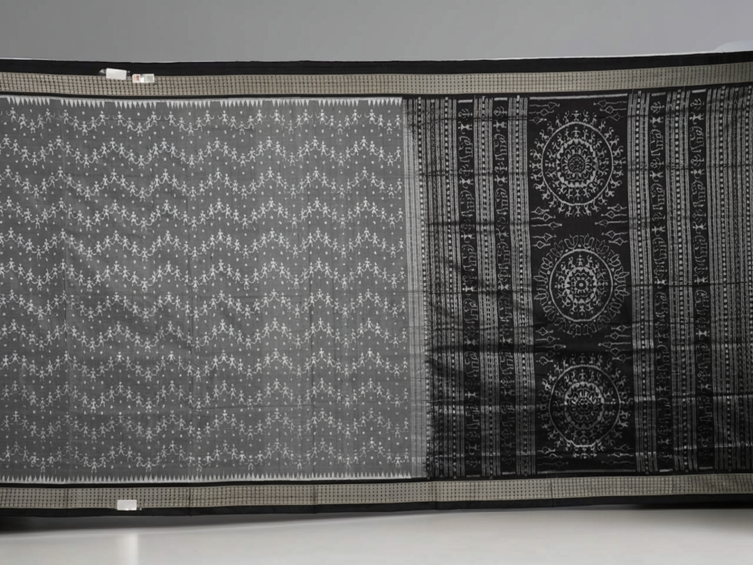 Close-up of grey & black Sambalpuri silk saree fabric, highlighting its rich texture and weave.