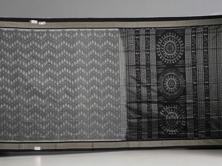 Close-up of grey & black Sambalpuri silk saree fabric, highlighting its rich texture and weave.