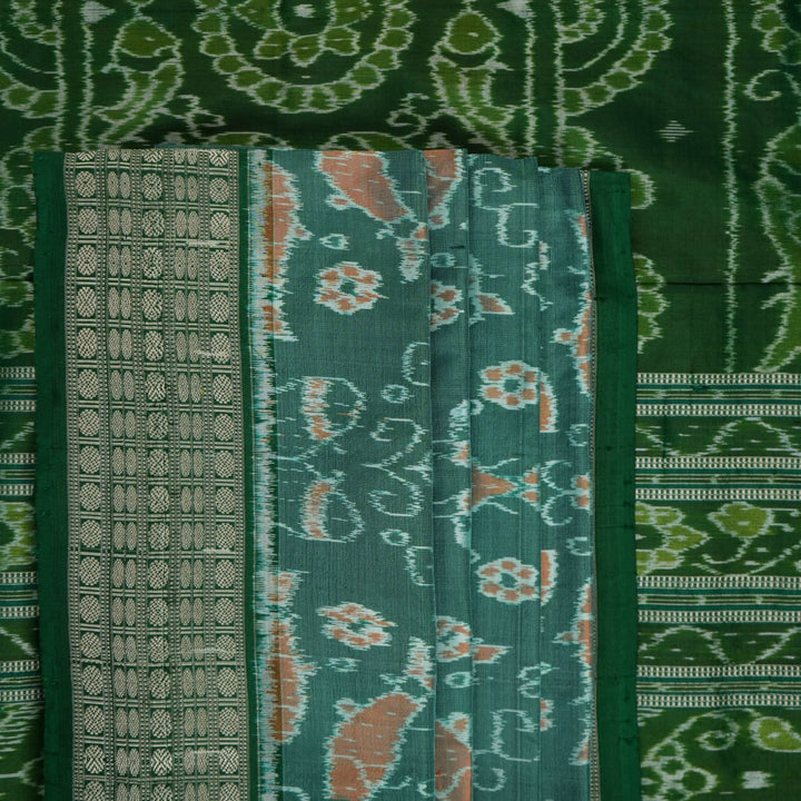 Ultra close-up of green Sambalpuri silk saree fabric, highlighting its luxurious texture and weave.