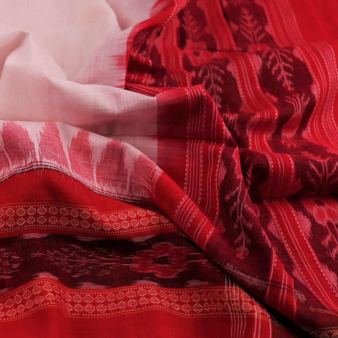 A woman wearing a white and red Sambalpuri cotton dupatta with a plain pattern, draped over her shoulder