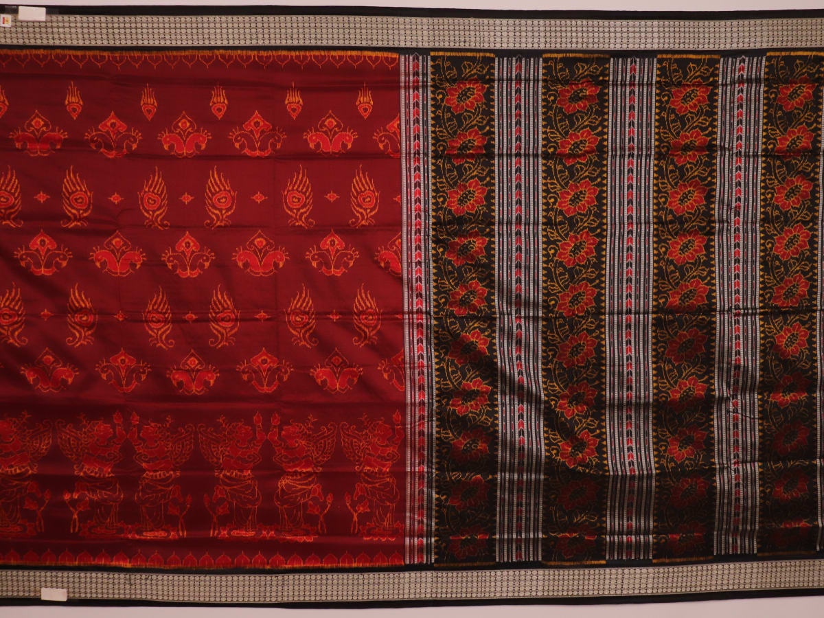 Close-up of intricate motifs on a maroon Sambalpuri silk saree