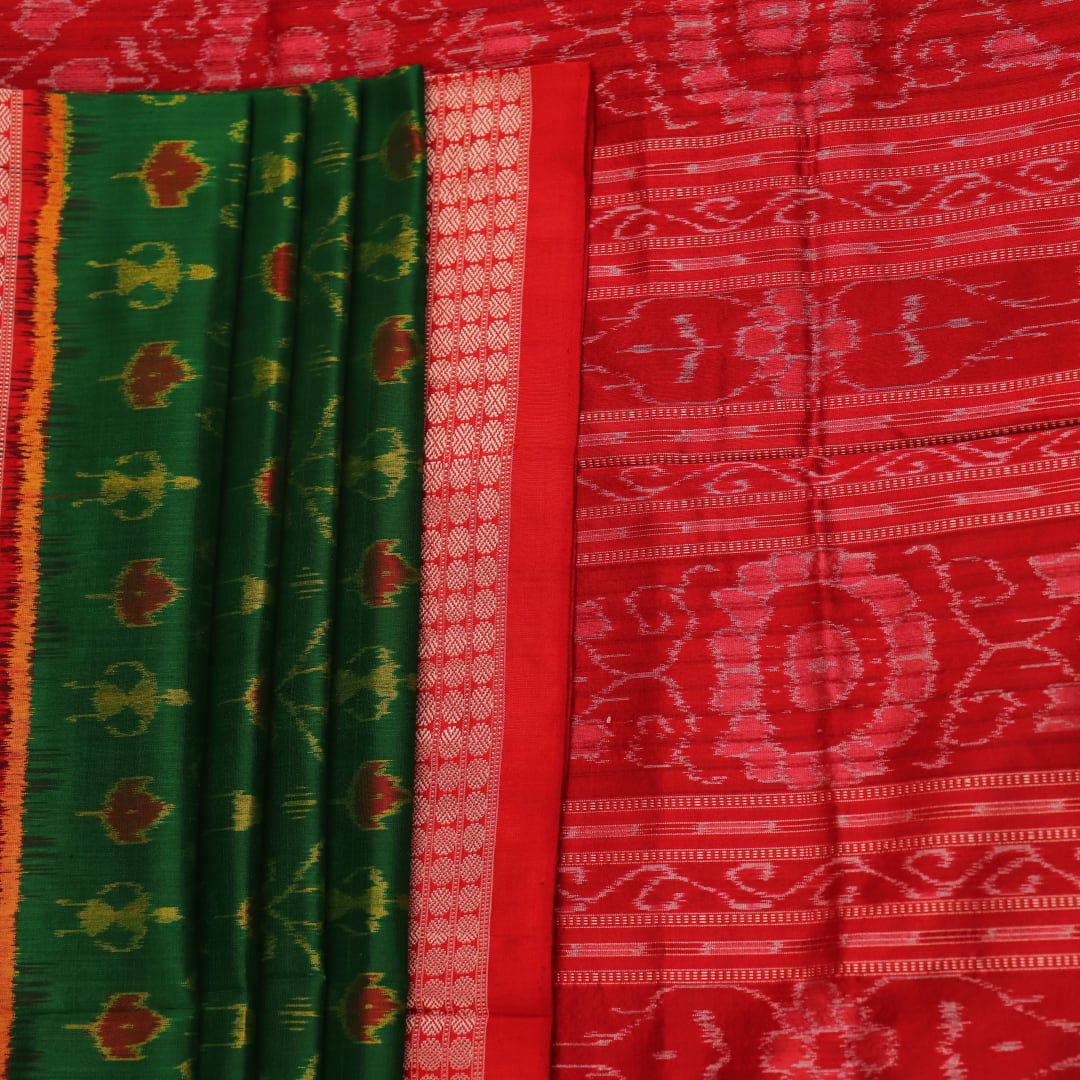 Close-up of green and orange silk Sambalpuri saree fabric with intricate motif patterns