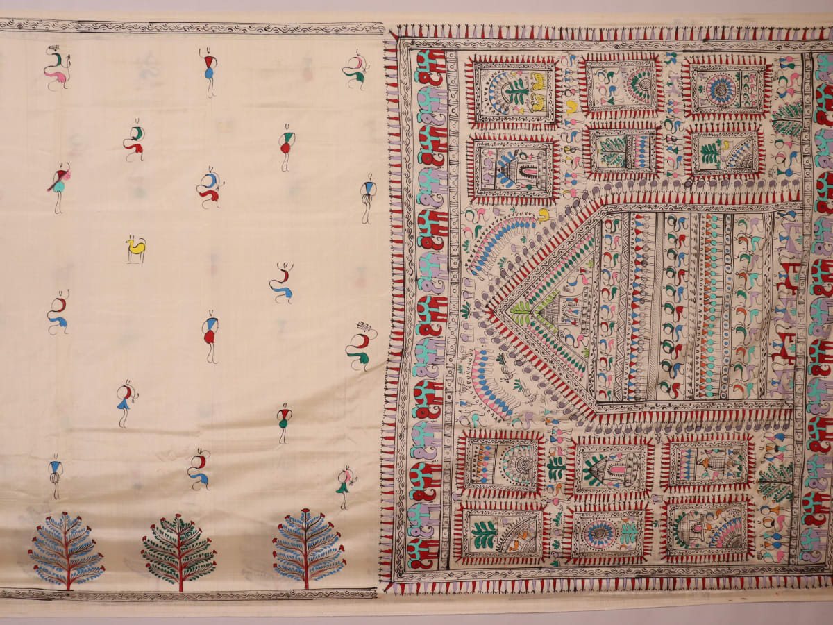 Close-up of the white silk saree fabric texture, showcasing the handloom weave and painted Patachitra details.