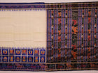 White silk Khandua saree with blue motifs, draped in traditional style