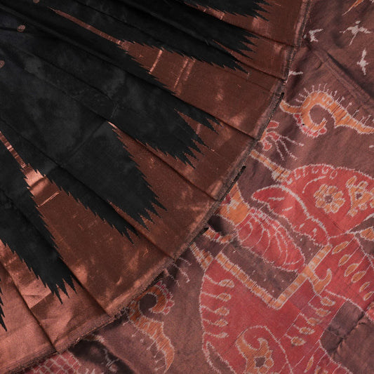 Extreme close-up showing the rich black and brown Sambalpuri Silk fabric texture and intricate handloom weave.