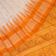 Close-up of Bomkai silk saree fabric texture in white with yellow butta pattern.