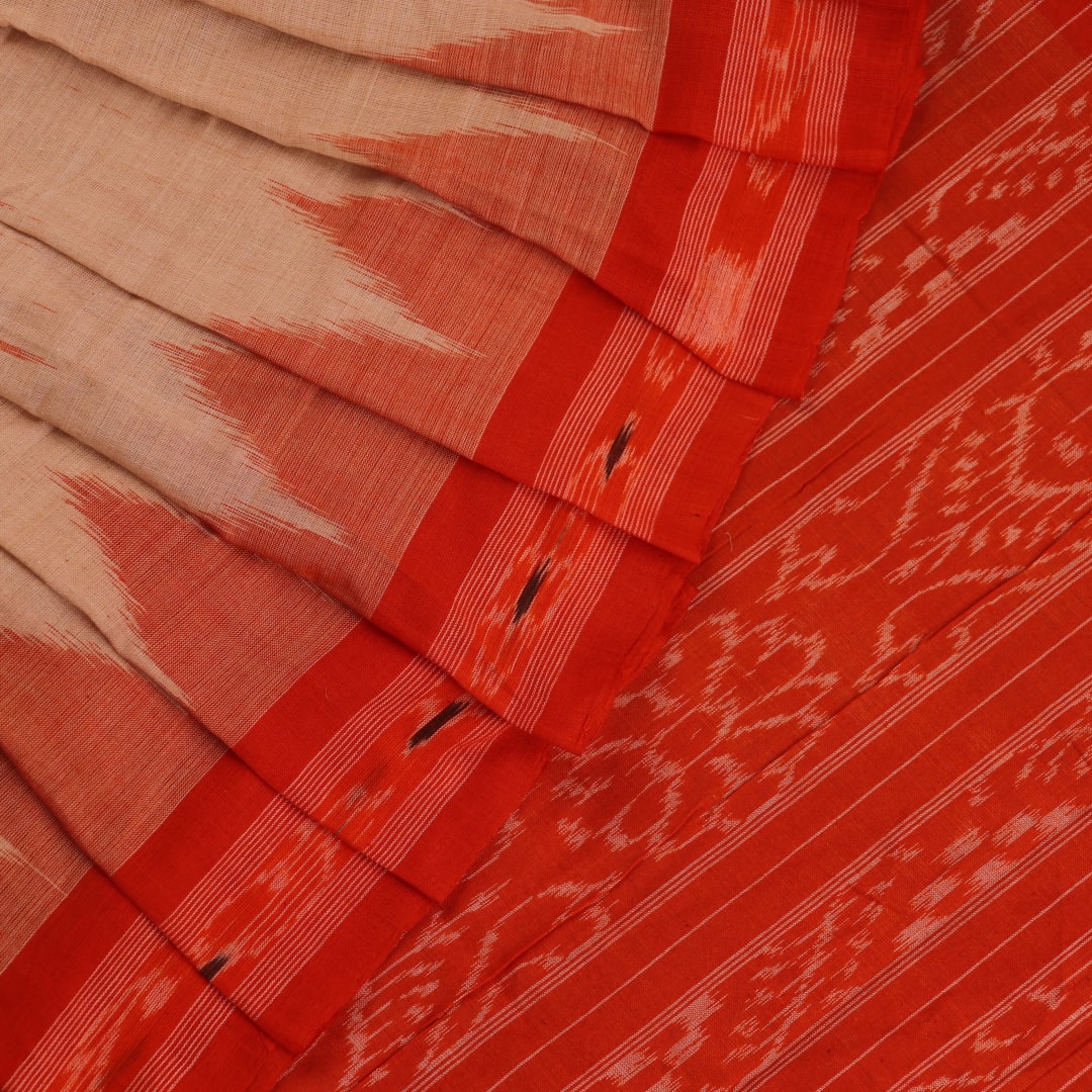 Cream and orange Sambalpuri cotton saree draped, showcasing traditional motifs and handloom texture.