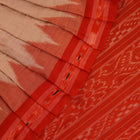 Cream and orange Sambalpuri cotton saree draped, showcasing traditional motifs and handloom texture.