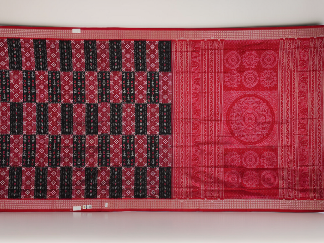 Close-up of the rich, smooth texture of the black Sambalpuri silk saree fabric.