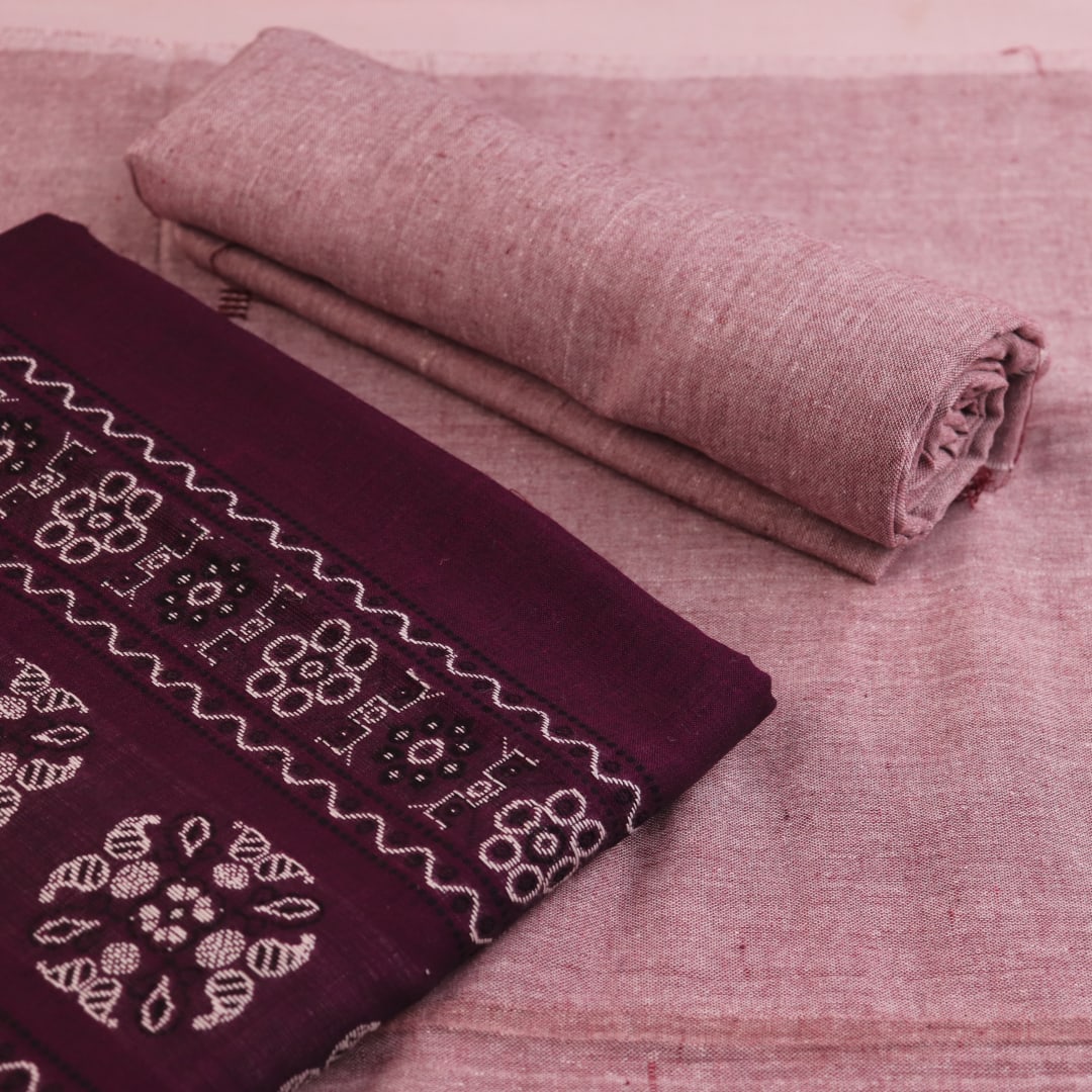 Close-up of Bomkai cotton dress material's matching blouse piece in brown with subtle purple details.