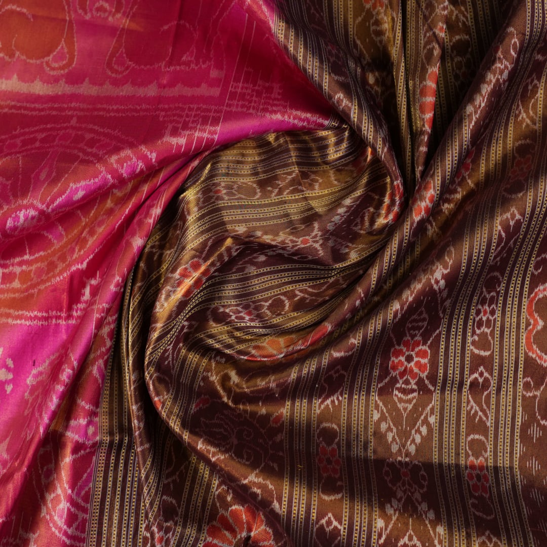 Close-up of Sambalpuri silk fabric texture, highlighting the fine weave in pink and maroon with delicate tissue motifs.
