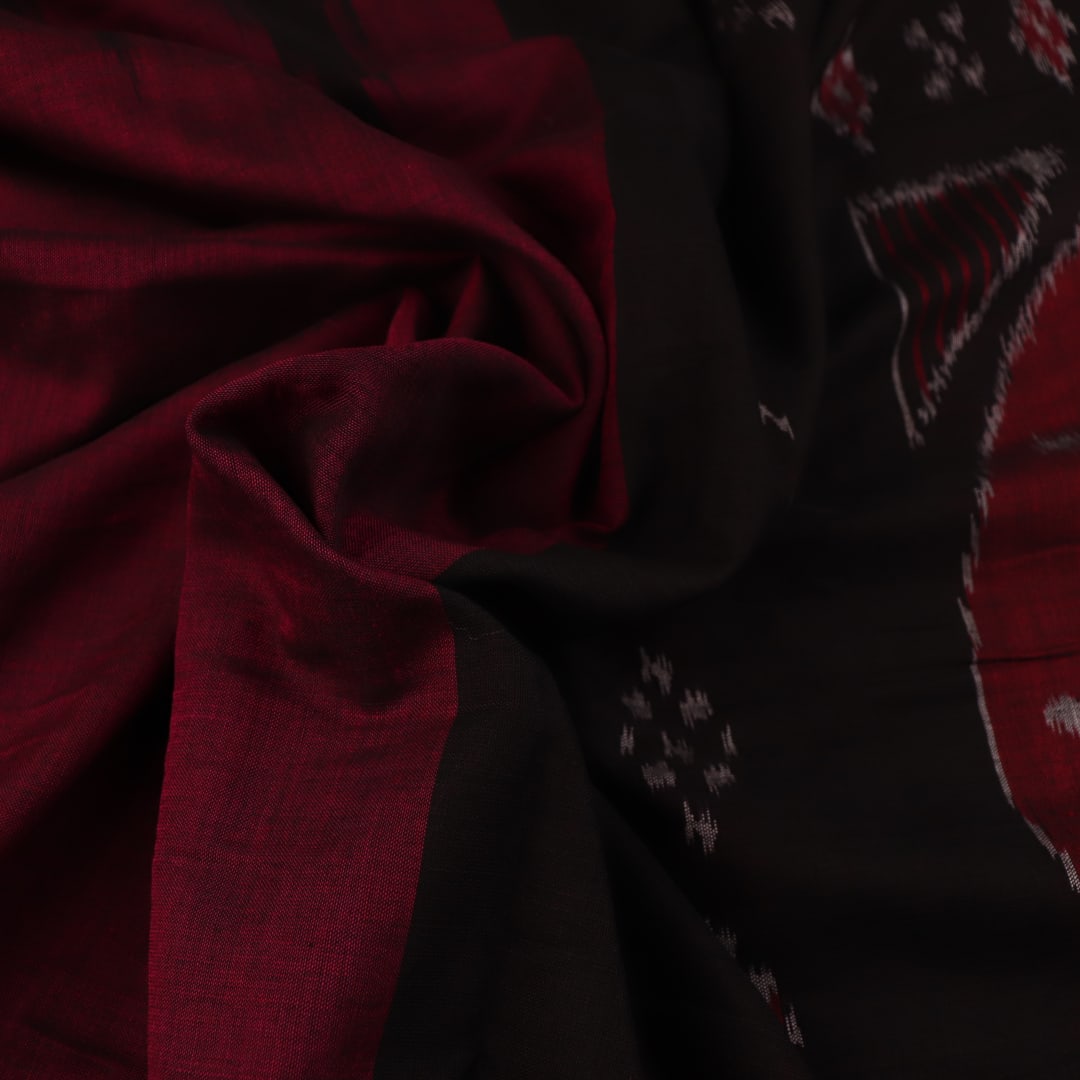 Plain maroon and black Sambalpuri cotton saree, elegantly draped.