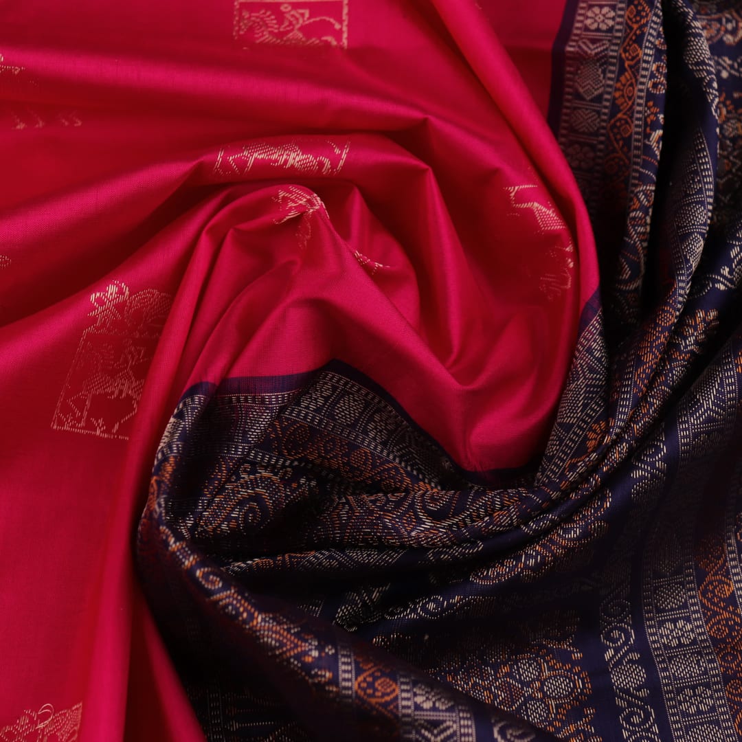 Close-up view of soft, lustrous silk fabric with intricate butta patterns in pink and blue