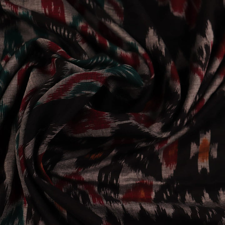 A woman draped in a grey and black cotton Sambalpuri saree, showcasing intricate motifs on the pallu and body.