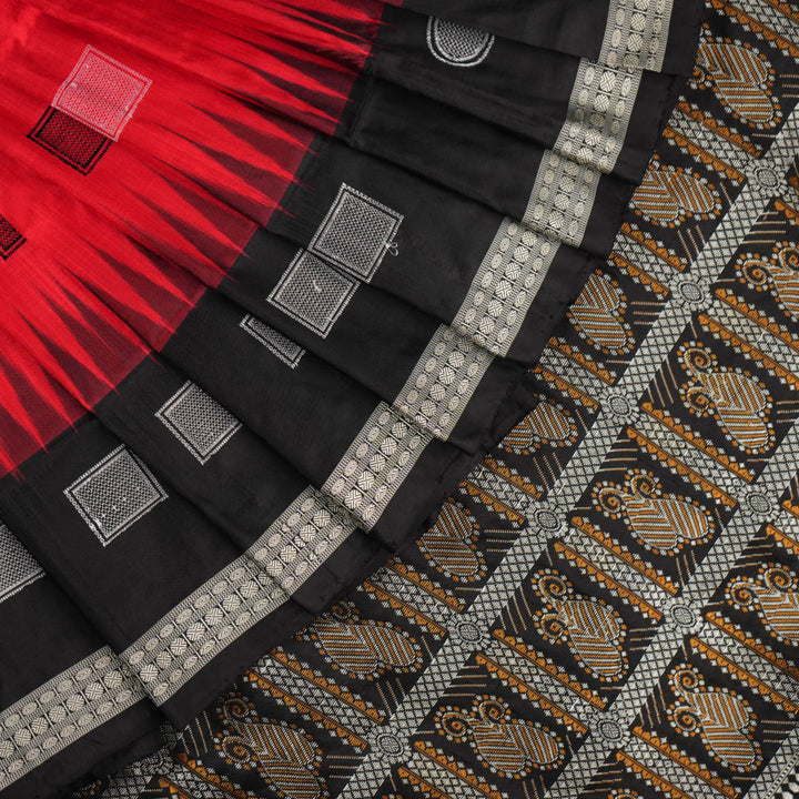 Extreme close-up of red Bomkai silk saree fabric showcasing rich texture and intricate weave.