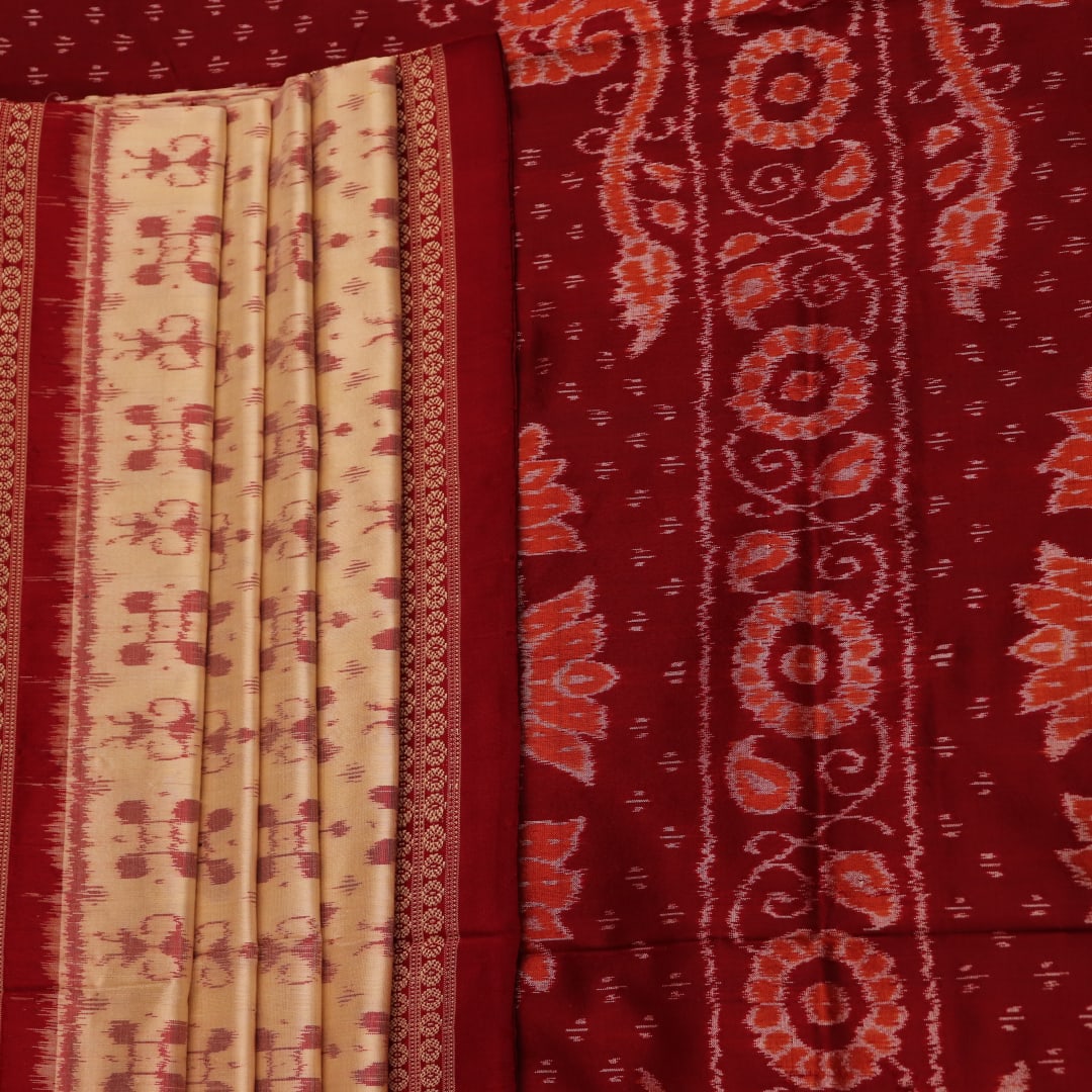 Close-up showcasing the intricate cream and maroon silk fabric texture with Sambalpuri motifs