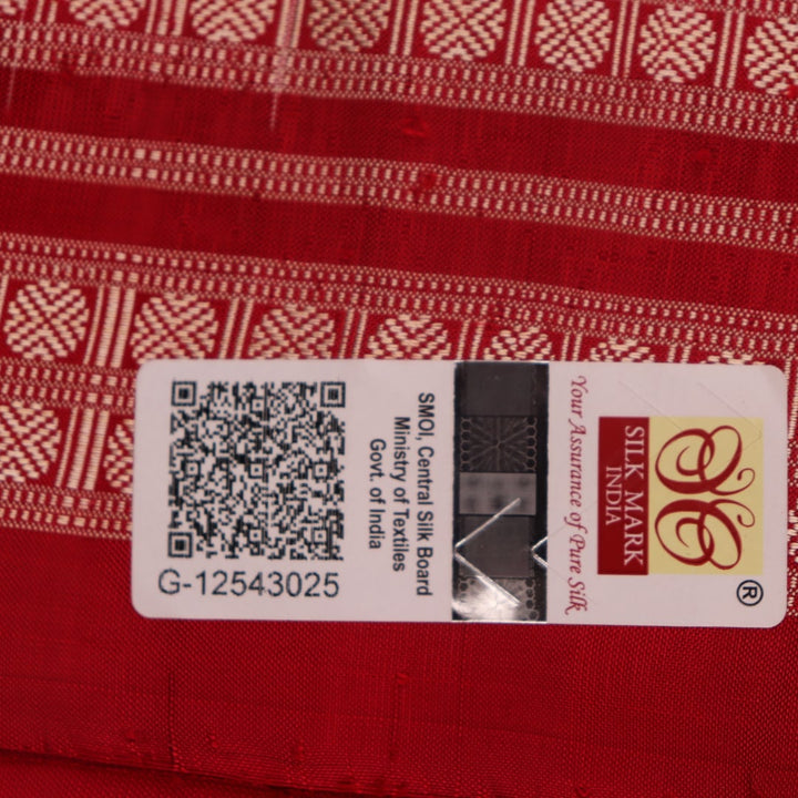 Close-up of grey and red Sambalpuri silk saree fabric showing intricate woven motif texture.
