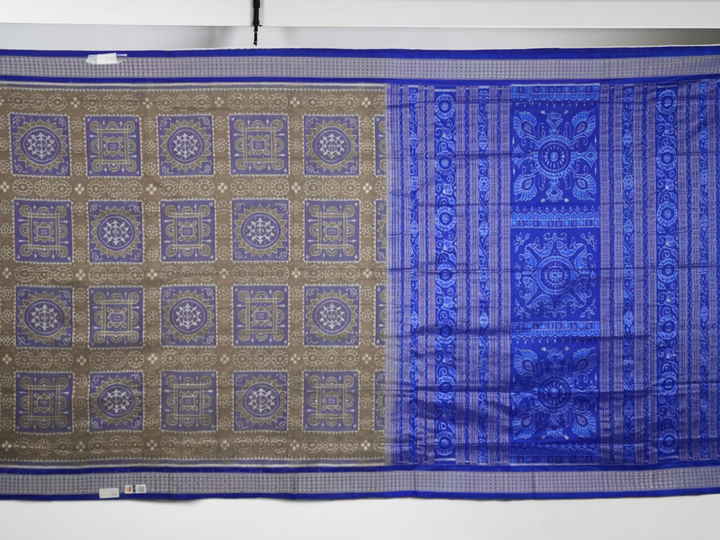 Extreme close-up of the grey and blue Sambalpuri silk saree fabric, revealing its rich texture and intricate weave.