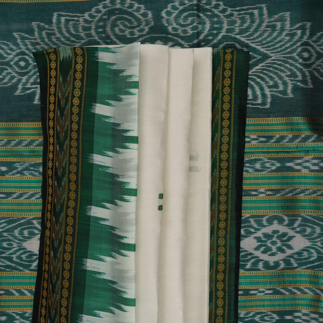 Model wearing a white Khandua silk saree with green butta and border, showcasing a graceful drape.